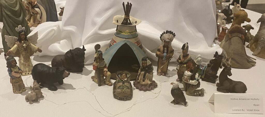 A nativity scene made form resin by Violet Knox. Alongside Mary, Joseph, and Baby Jesus, an angel, the Shepard, farm animals and the three wise men are depicted as well.