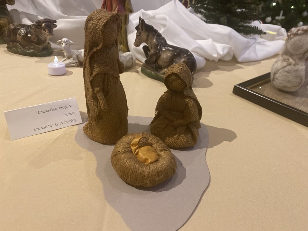 A nativity scene made from burlap by Lynn Cushing. Joseph, Mary, and Baby Jesus are depicted.