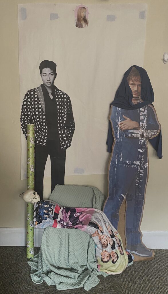 A makeshift nativity scene. Starting at the foreground, from left to right: Kim Namjoon from the boy group BTS, Jerma the Skeleton, Will Graham from the NBC show Hannibal, and American Rapper Ice Spice.